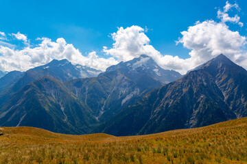 Hiking near ski station Les deux Alpes and view on Alpine mountains peaks in summer, Isere, France