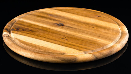 wooden round Board for serving on an empty black background