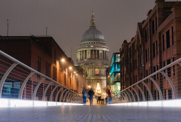 View from the Millennium Bridge of the Saint Paul's Cathedral in the city of London illuminated at dusk