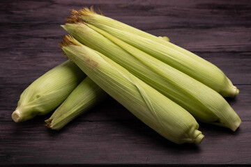 Fototapeta premium corn cobs on a dark wooden table