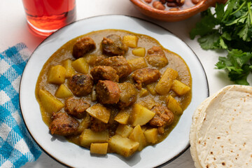 Mexican longaniza with green sauce and potato on white background