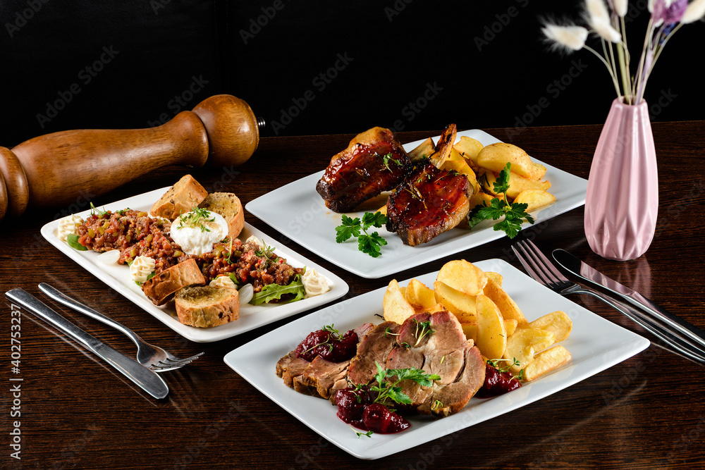 Poster dinner table with different dishes, three-course set on the table. different food on a wooden table.