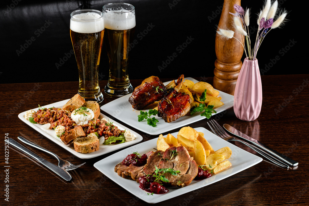 Poster dinner table with different dishes, three-course set on the table. different food on a wooden table.