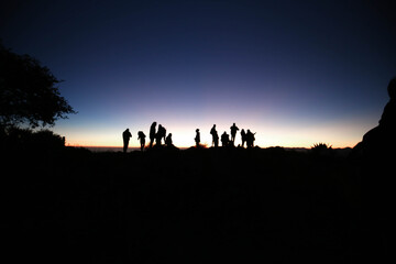 Fototapeta na wymiar silhouette of people and Epic and colorful sunrise in the to mountains