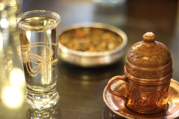 Traditional presentation of famous Turkish coffee in a local coffee shop in Gaziantep, Turkey with a glass of water with Ottoman tughra.