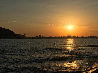beautiful and colorful sunrise in the beach with some clouds