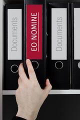 Eo Nomine. Folder with label on the shelf of a lawyer. Red label with text in focus.