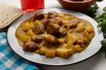 Mexican longaniza with green sauce and potato on white background