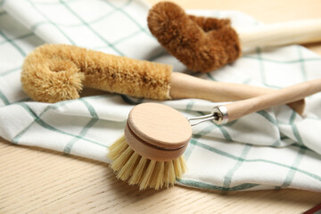 Cleaning brushes for dish washing on wooden table, closeup
