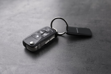 Modern car flip key with trinket on grey background