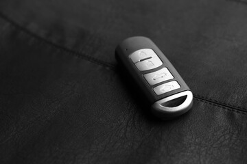 Modern car smart key on leather background. Space for text