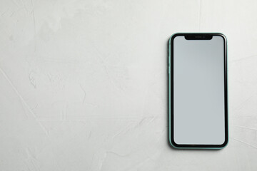 MYKOLAIV, UKRAINE - JULY 9, 2020: New modern Iphone 11 with blank screen on grey table, top view....