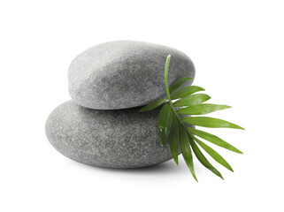 Obraz na płótnie Canvas Grey spa stones and tropical leaf on white background