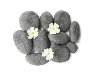 Fototapeta na wymiar Spa stones and flowers on white background, top view