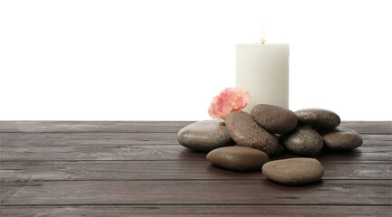 Obraz na płótnie Canvas Spa stones, flower and candle on wooden table against white background. Space for text