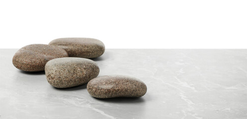 Fototapeta na wymiar Spa stones on light grey table against white background. Space for text