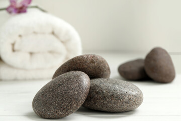Pile of spa stones on white wooden table, closeup