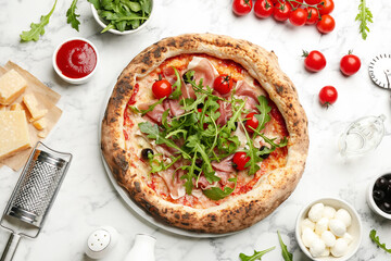 Tasty pizza with meat and arugula on white marble table, flat lay