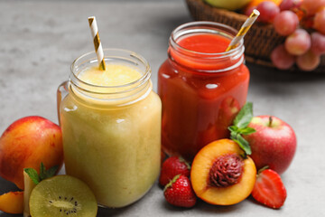 Delicious juices and fresh ingredients on grey table, closeup