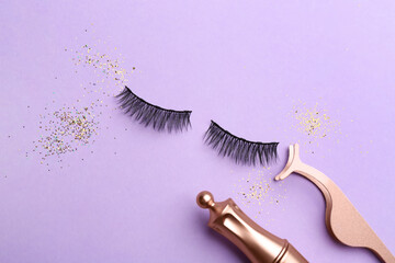 Flat lay composition with magnetic eyelashes and accessories on violet background