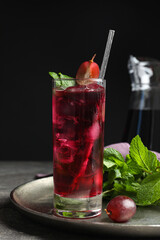Delicious grape soda water with mint on grey table. Refreshing drink