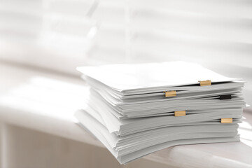 Stack of blank paper on window sill indoors