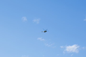 helicopter on a background of blue sky with clouds