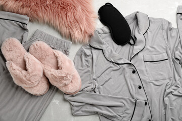 Flat lay composition with fluffy slippers and pajamas on grey background. Comfortable home outfit