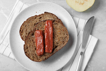 Sandwich with quince paste on light grey marble table, flat lay
