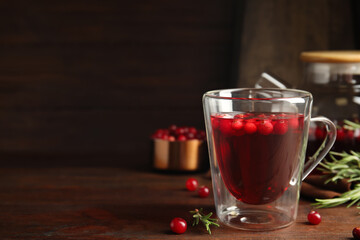 Tasty hot cranberry tea on wooden table. Space for text