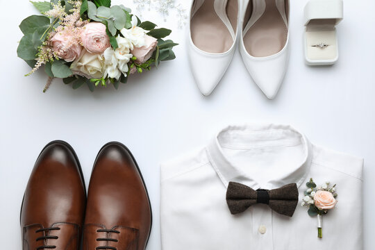 Composition with wedding shoes for bride and groom on white background, top view