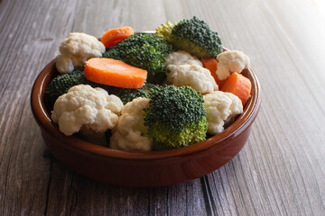 Recipiente con una mezcla de verduras: brócoli, coliflor y zanahoria.