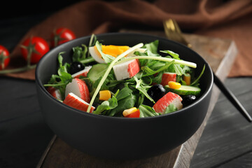 Tasty crab stick salad served on grey wooden table, closeup