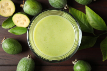 Fresh feijoa smoothie in glass on wooden table, flat lay