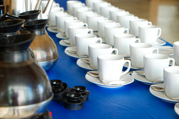 Coffee cup on table with coffee pouring from jar