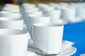 Coffee cup on table with coffee pouring from jar