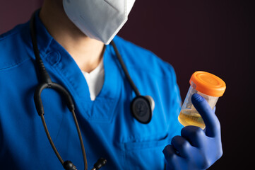 male nurse holding a urine specimen in a container