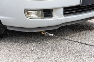 Cable attached to broken down car being pulled onto tow truck
