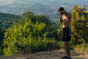 Handsome shirtless guy setup music on mobile device for running