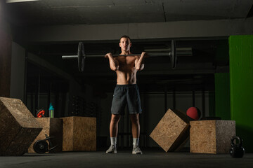 Fit strong shirtless athlete doing squats. Hardcore Cross-fit workout concept.