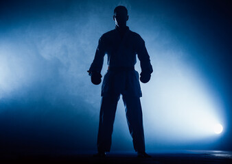 The karate guy in white kimono and black belt training karate