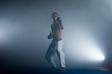 The karate guy in white kimono and black belt training karate