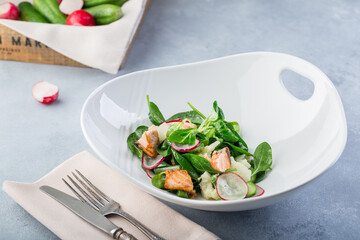 Delicious fresh salad with red fish and vegetables. Hot salad with salmon