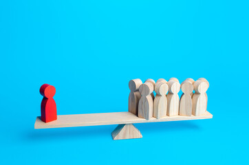 The red human figurine has equal weight against a group of people. Leader and valued employee....