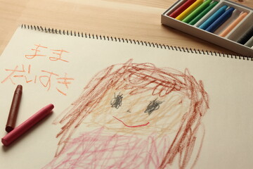 子供がクレヨンでスケッチブックに描いた母親の絵