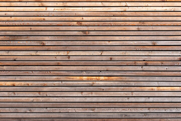 Texture pattern of a brown wood facade with planks. Aged timber structure closeup.