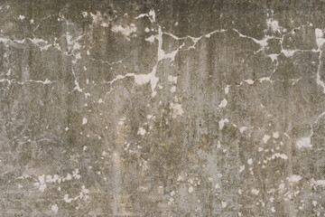 Texture pattern of a rough grunge wall with cracks in the plaster material. Aged vintage structure with fine elements.
