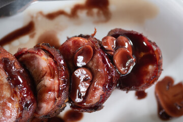 Roasted pork steak wrapped in bacon with sauce