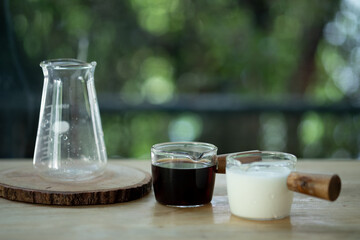 Hot black coffee  and fresh milk in mini transparent glass cup