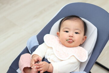 リビングで離乳食を食べさせてもらう赤ちゃん